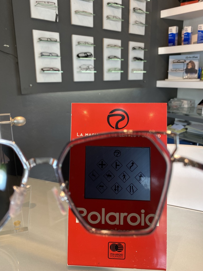 Demostración de lentes polarizados sobre un exhibidor rojo en el local